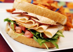 Sliced Turkey Sandwich with an Arugula Tomato Blend